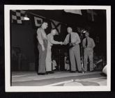 USS Saratoga birthday party, 4 men on stage  